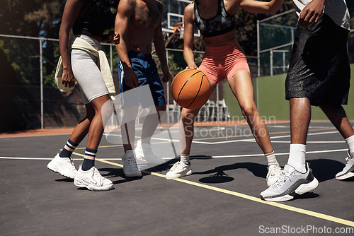 Image of You have to be fast on your feet. Closeup shot of a group of sporty young people playing basketball on a sports court.