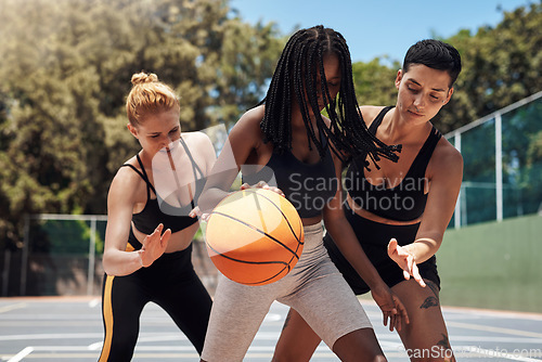 Image of Dribbling the ball down the court. a group of sporty young women playing basketball on a sports court.