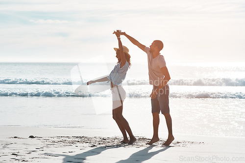 Image of True love stories never have endings. a young couple dancing together at the beach.