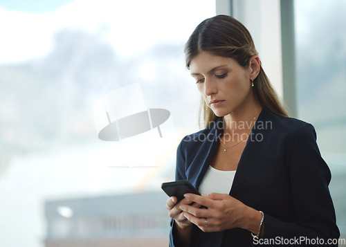 Image of Ill have to call this client asap. a businesswoman using her cellphone at the office.