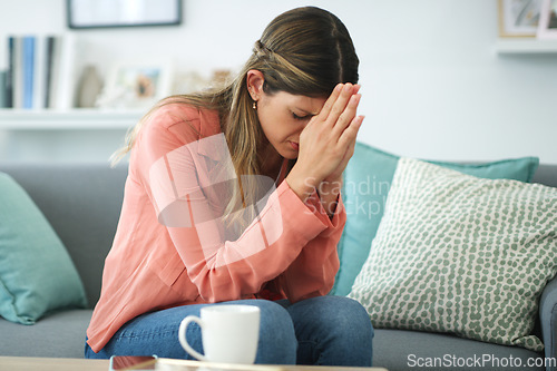 Image of Dealing with lifes tests. a young woman looking upset while sitting at home.