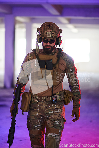 Image of A professional soldier undertakes a perilous mission in an abandoned building illuminated by neon blue and purple lights