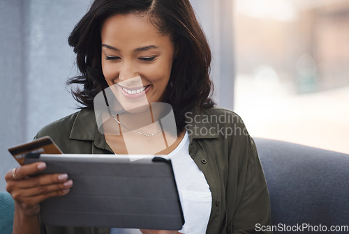 Image of Shes been given the gift of convenience. an attractive young woman using a digital tablet and credit card on the sofa at home.