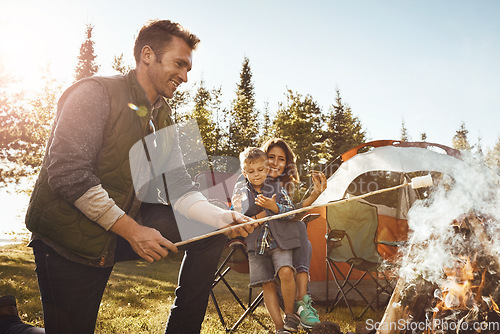 Image of Lets roast some marshmallows. a young family camping in the forest.