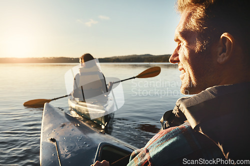 Image of Watching her back while we kayak. a young couple kayaking on a lake outdoors.