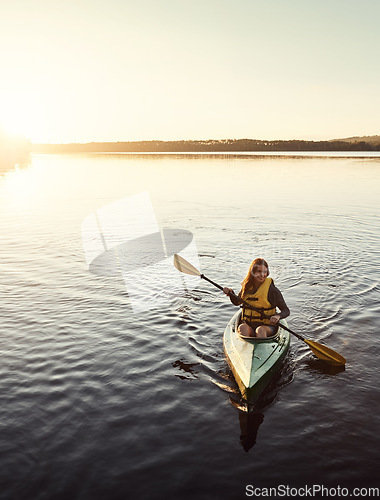 Image of She finds peace being alone on the water. a beautiful young woman kayaking on a lake outdoors.