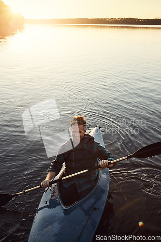 Image of Happy to be kayaking. High angle shot of a young man kayaking on a lake outdoors.