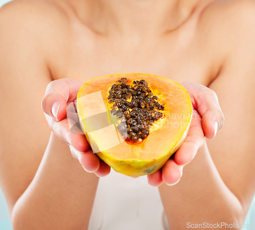 Image of Papaya. Studio shot of an unrecognizable young woman posing with a papaya against a light background.