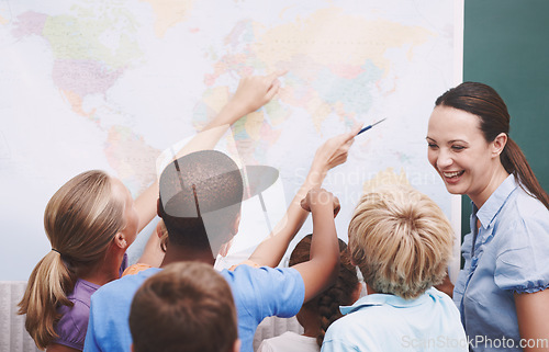 Image of Geography can be fun. A group of children looking at a world map during geography class.