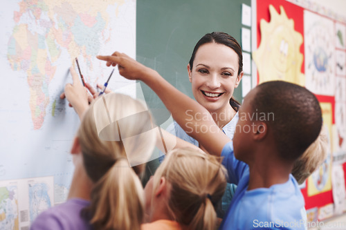 Image of Enthusiastic about teaching. An excited class pointing at a world map with their geography teacher.