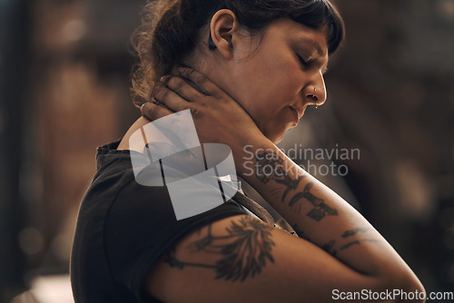 Image of Heavy lifting does a number on your ligaments. a young woman experiencing neck pain while working at a foundry.