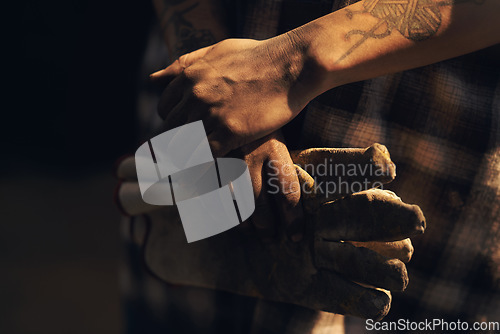 Image of Hardworking hands hold a lot of pride. an unrecognisable holding a pair of gloves while working at a foundry.