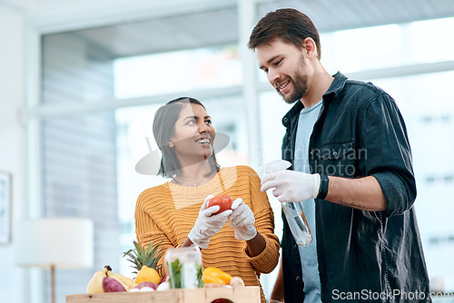 Image of Disinfecting your groceries, welcome to 2020. a young couple disinfecting their groceries at home.