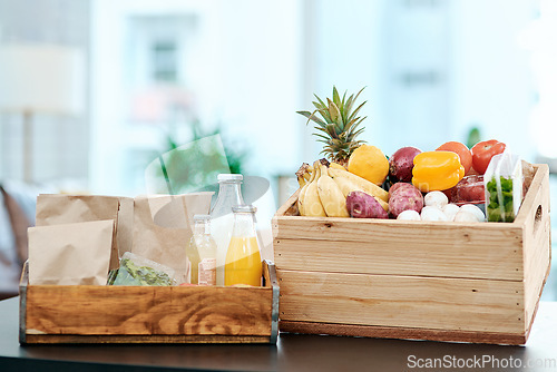 Image of Make your home a hub of health. a box full of fresh produce on a kitchen counter at home.