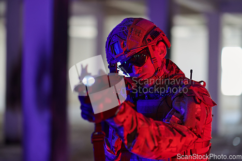 Image of A professional soldier undertakes a perilous mission in an abandoned building illuminated by neon blue and purple lights