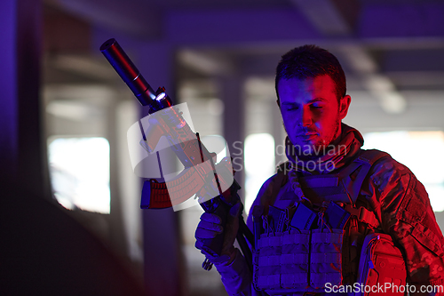 Image of A professional soldier undertakes a perilous mission in an abandoned building illuminated by neon blue and purple lights