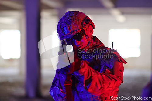 Image of A professional soldier undertakes a perilous mission in an abandoned building illuminated by neon blue and purple lights