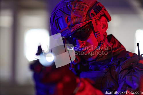 Image of A professional soldier undertakes a perilous mission in an abandoned building illuminated by neon blue and purple lights