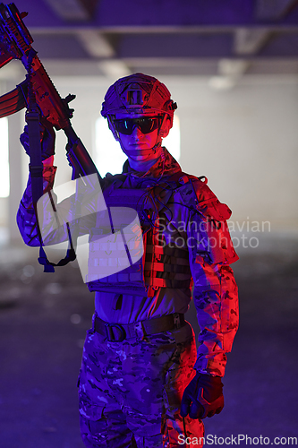 Image of A professional soldier undertakes a perilous mission in an abandoned building illuminated by neon blue and purple lights