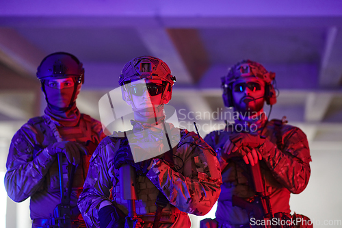 Image of Soldier squad team walking in urban environment colored lightis