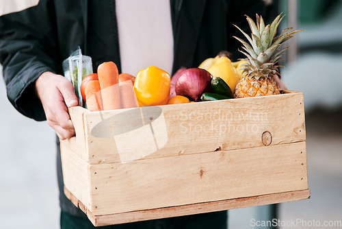 Image of As fresh as it would be from your garden. a man delivering fresh fruit and vegetables to a place of residence.