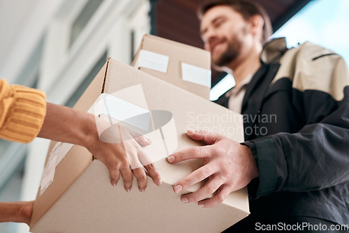 Image of Take care not to touch. a young man delivery a package to a woman at home.