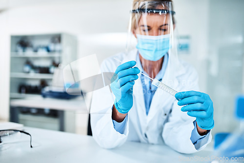 Image of We can make a more accurate diagnosis based off your DNA. a scientist holding a sampling swab and test tube in a lab.