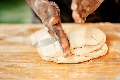 Image of It takes skill to make the best. a male baker busy shaping dough at work.