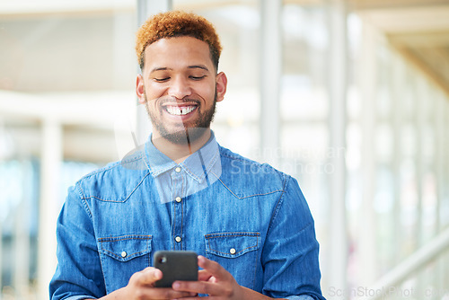 Image of Gaining more followers with an attention grabbing social media post. a young businessman using a smartphone in a modern office.