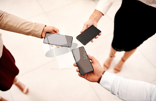 Image of Closing in on their business connections. Closeup shot of a group of unrecognisable businesspeople holding cellphones.