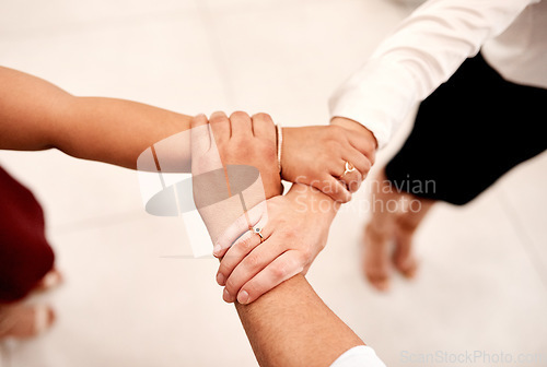 Image of Inspired to band together and celebrate collaboration. Closeup shot of a group of unrecognisable businesspeople holding on to each others arms.