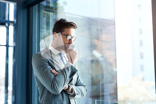 Image of Hes planning to franchise all over the city. a professional businessman looking thoughtful while standing in his office.