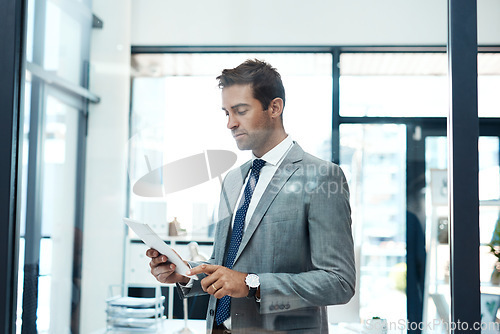 Image of Im always in contact with my clients. a professional businessman using a digital tablet in his office.