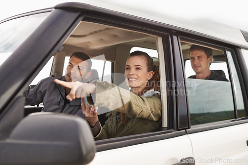 Image of Theres where we need to be. a young woman shpowign her friend where to go while on a roadtrip.