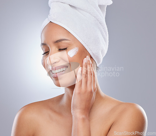 Image of Maintaining smooth skin is a challenge I enjoy. an attractive young woman applying moisturiser to her skin in the studio.