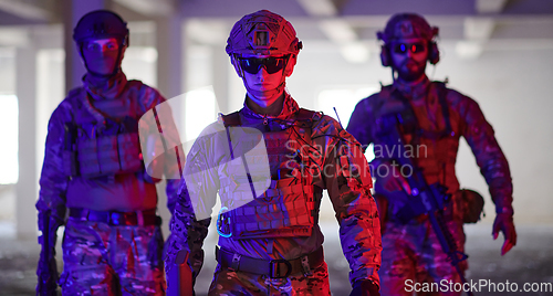 Image of Soldier squad team walking in urban environment colored lightis