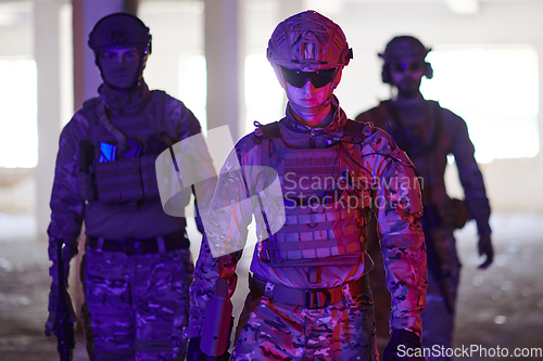 Image of Soldier squad team walking in urban environment colored lightis