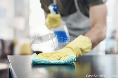 Image of Bust that dirt with a bit of elbow grease. an unrecognisable man disinfecting a table at home.