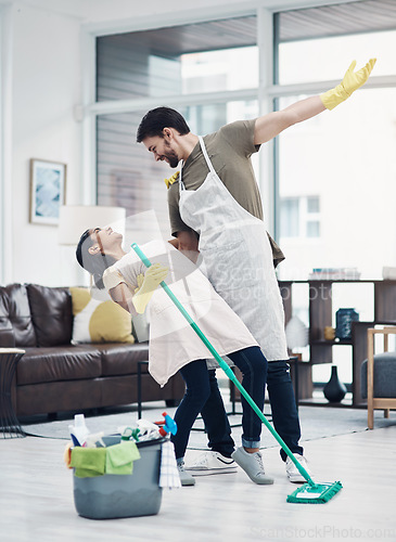 Image of Nothing inspires productivity like passion. a happy young couple dancing while mopping the floor at home.