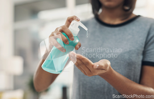 Image of One squeeze squashes those germs. an unrecognisable woman disinfecting her hands with sanitiser at home.