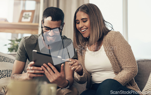 Image of Leveraging the internet to make their lives easier. a young couple using a digital tablet on the sofa at home.