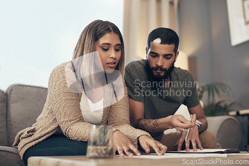 Image of Make your money grow with smart financial decisions. a young couple going over paperwork at home.