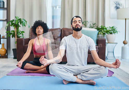 Image of Yoga made our relationship stronger. a young couple practising yoga in their living room.