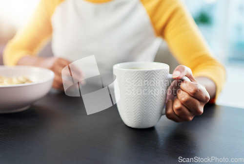 Image of The day starts after coffee. an unrecognizable woman having her morning coffee at home.