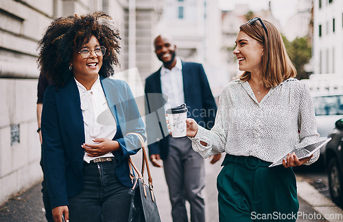 Image of Business minded people always get along. two businesswomen having a discussion while walking through the city together.