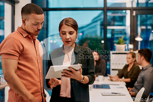 Image of He always seem to have the answers. two businesspeople discussing something on a digital tablet.