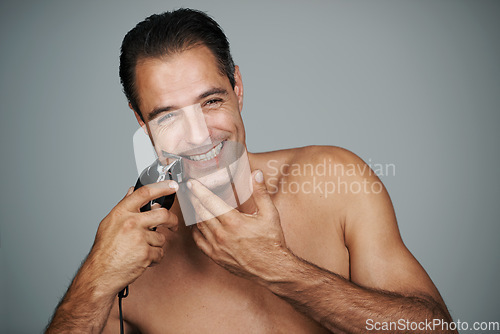 Image of Wow, that was a close shave. Portrait of a handsome mature man shaving his face with an electric razor.