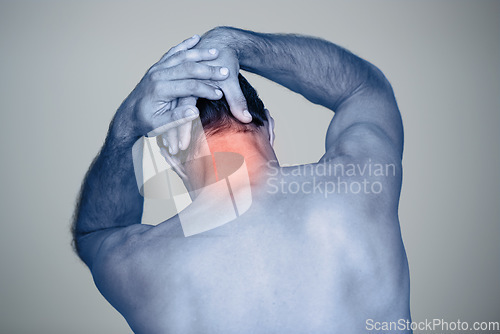 Image of In so much pain. Rear view shot of a mature man with neck pain thats highlighted in red.