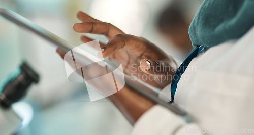 Image of Bettering her research with the help of smart tech. Closeup shot of an unrecognisable scientist using a digital tablet in a lab.