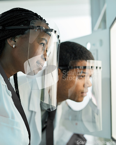 Image of Applying their great minds. two scientists wearing face shields while working together in a lab.